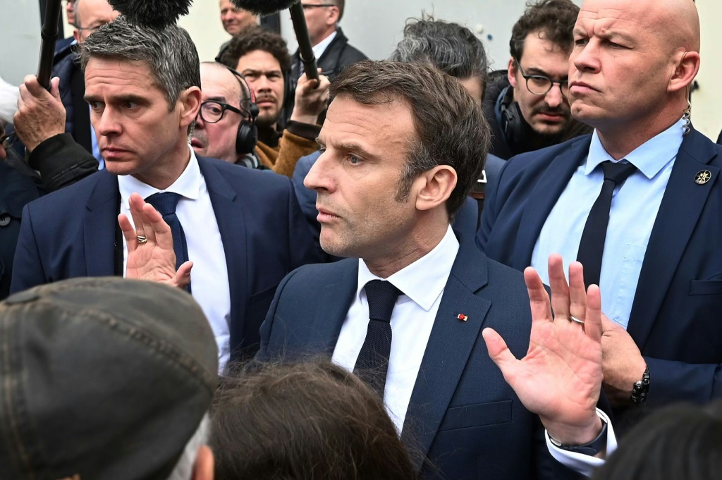 Macron booed by angry French after signing pensions reform