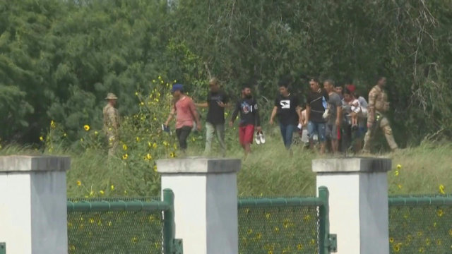 Migrants cross US-Mexico border and surrender to US Customs and Border Protection